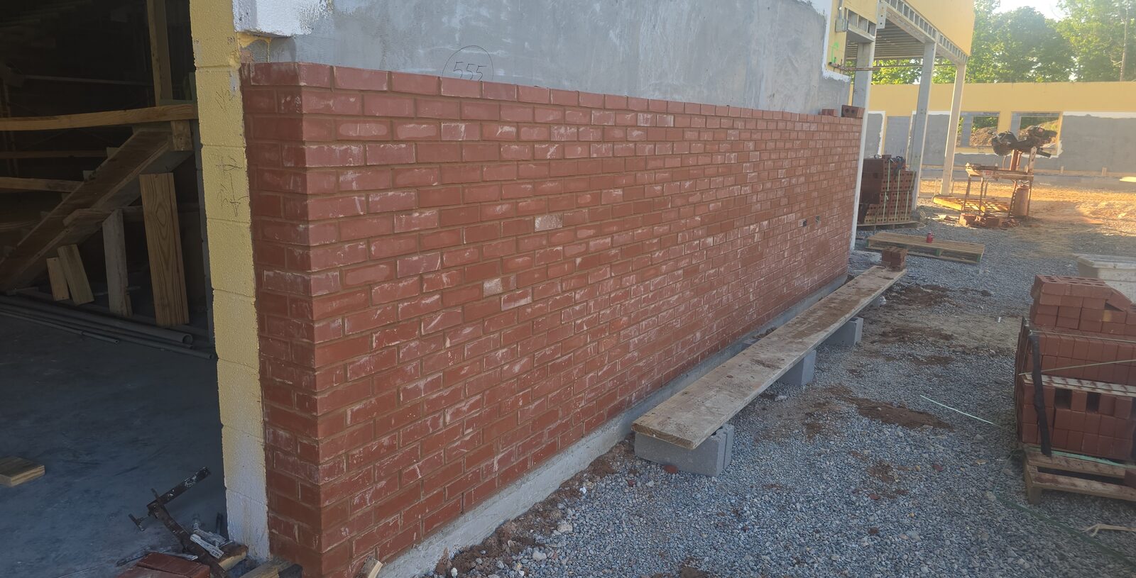 Plank resting on CMU blocks used as a masonry work platform